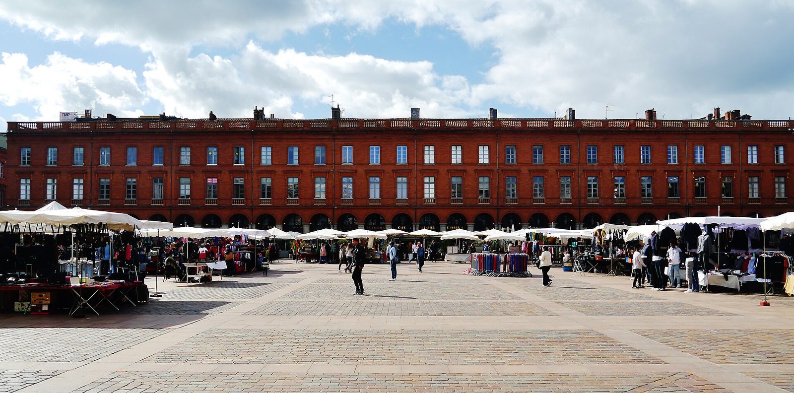 Marché de plein air à Toulouse avec des stands sous des tentes blanches